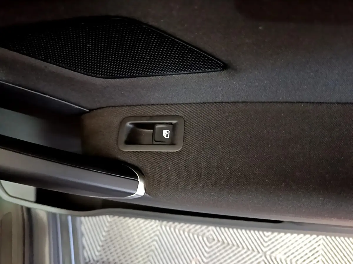 Détail de la poignée intérieure de porte arrière droite noire du Volkswagen Touran gris foncé 2023.