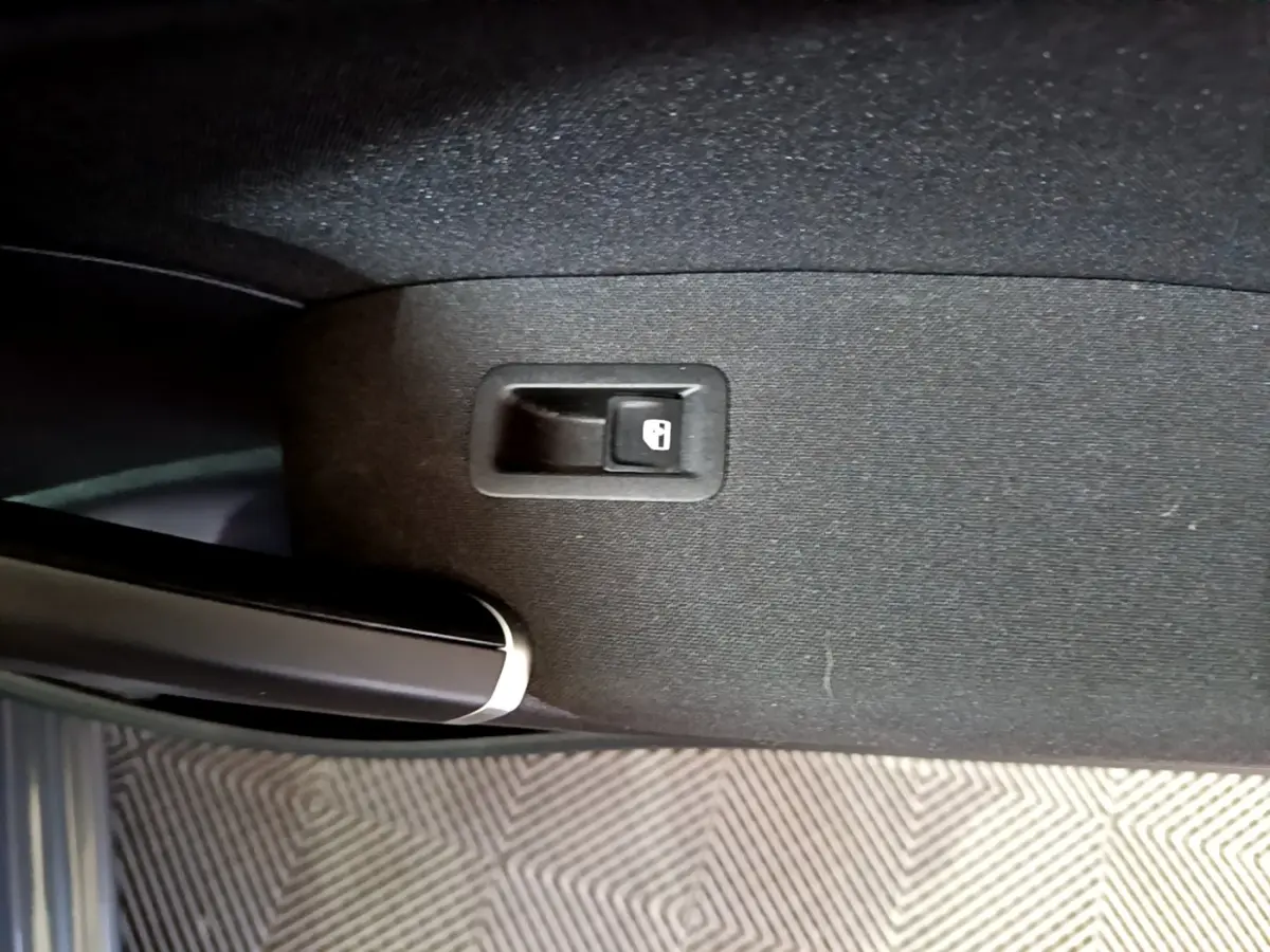 Bouton de verrouillage de porte sur la garniture intérieure côté gauche d'un Volkswagen Touran gris foncé 2023.