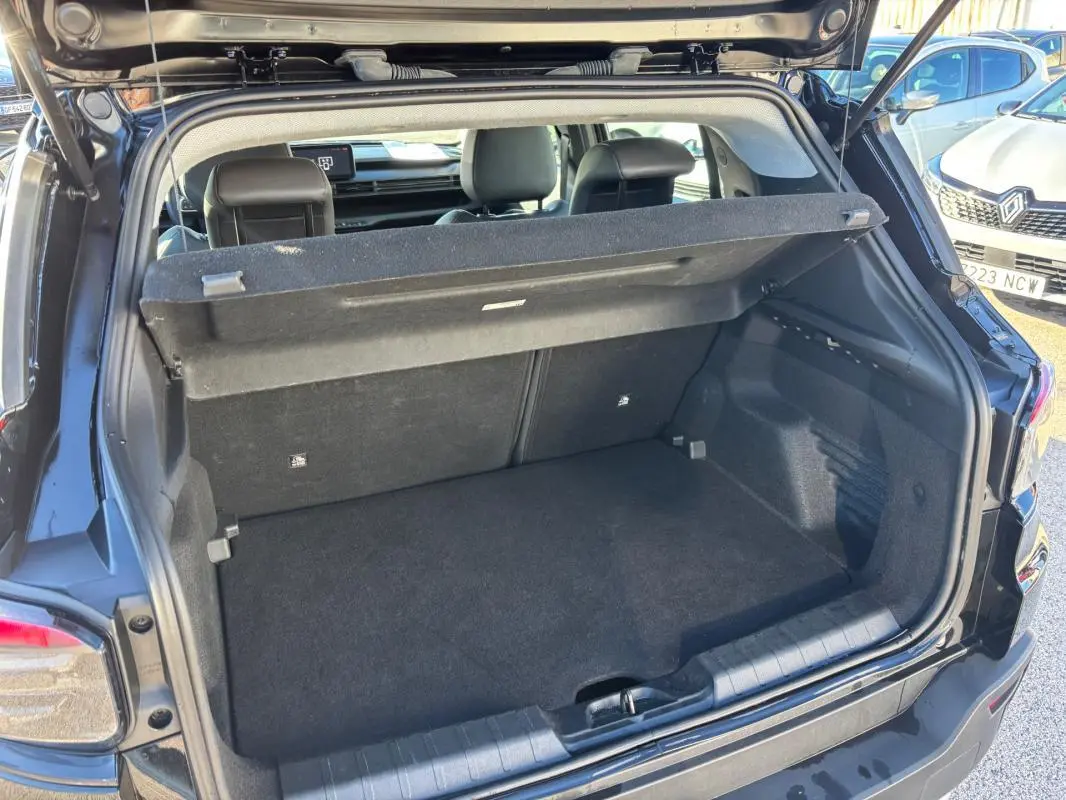 Coffre ouvert vu de l'arrière d'un Jeep Avenger noir 2024, montrant l'espace de chargement et la tablette cache-bagages.