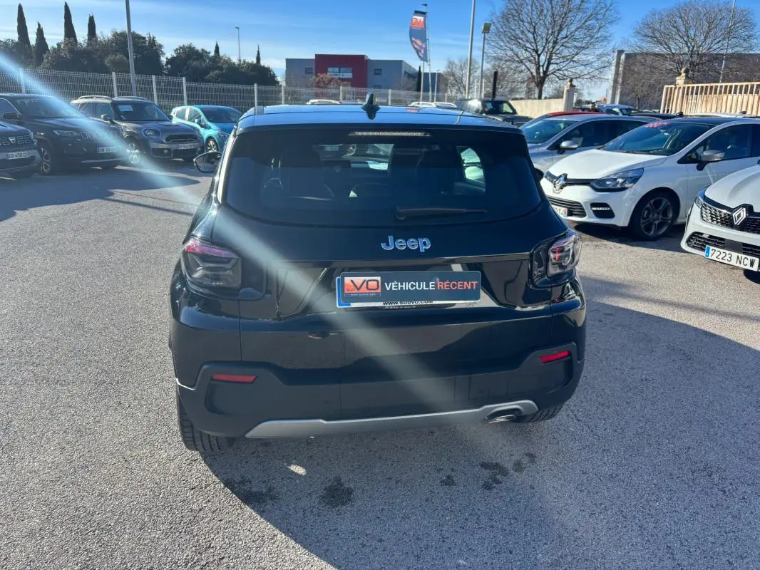Vue arrière d'un Jeep Avenger noir 2024 garé en extérieur, avec feux arrière LED et plaque d'immatriculation visible.
