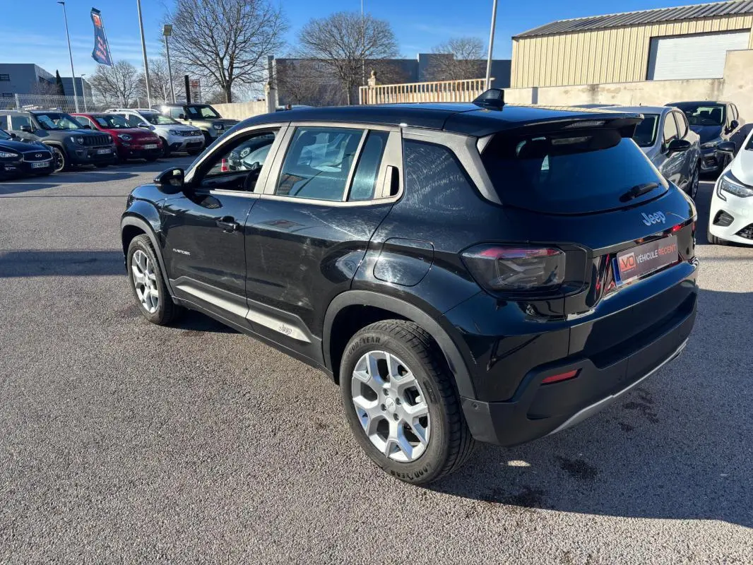 Jeep Avenger noir en vue 3/4 arrière droit, avec jantes alliage 17 pouces et toit noir contrasté.