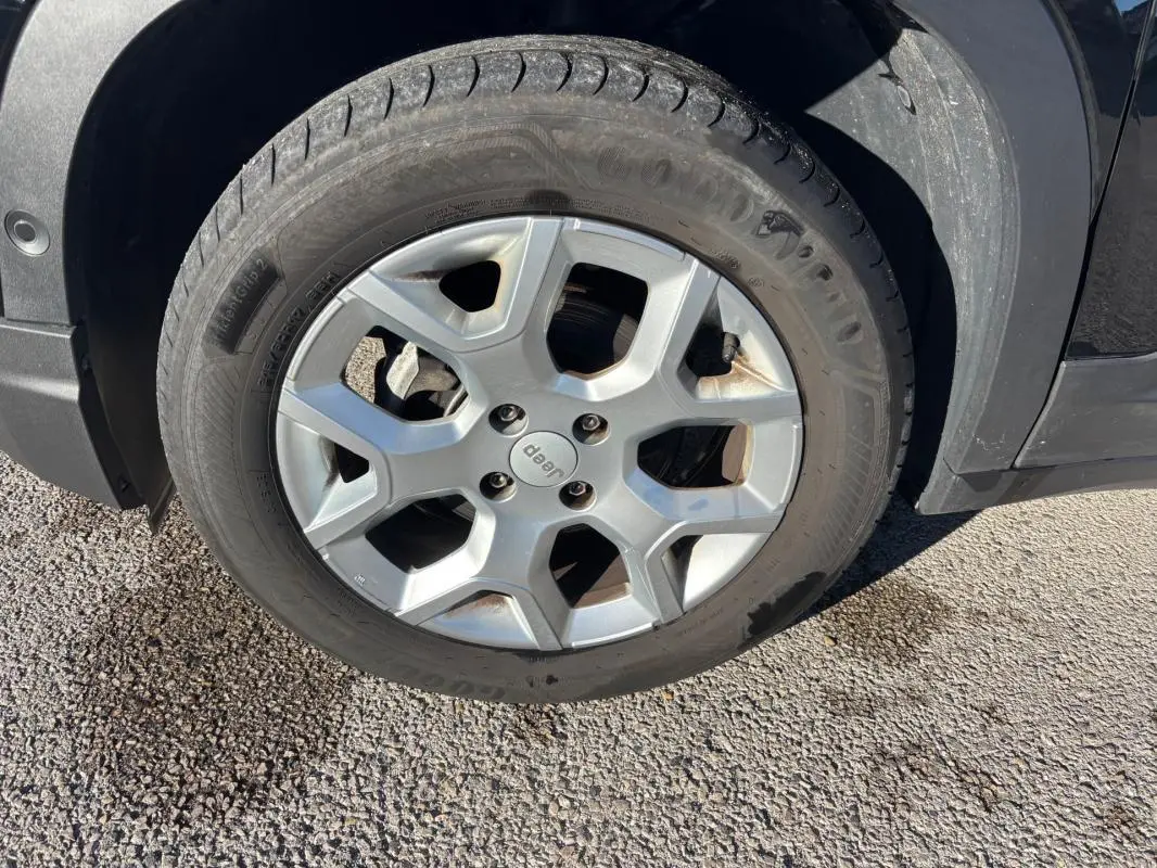 Gros plan sur la jante alliage 17 pouces argentée d’un Jeep Avenger noir, avec logo Jeep au centre.