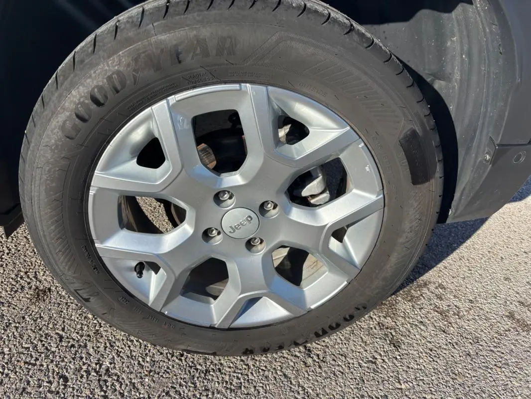 Gros plan sur la jante alliage grise de 17 pouces avec logo Jeep, montée sur un pneu Goodyear, sur un Jeep Avenger noir.