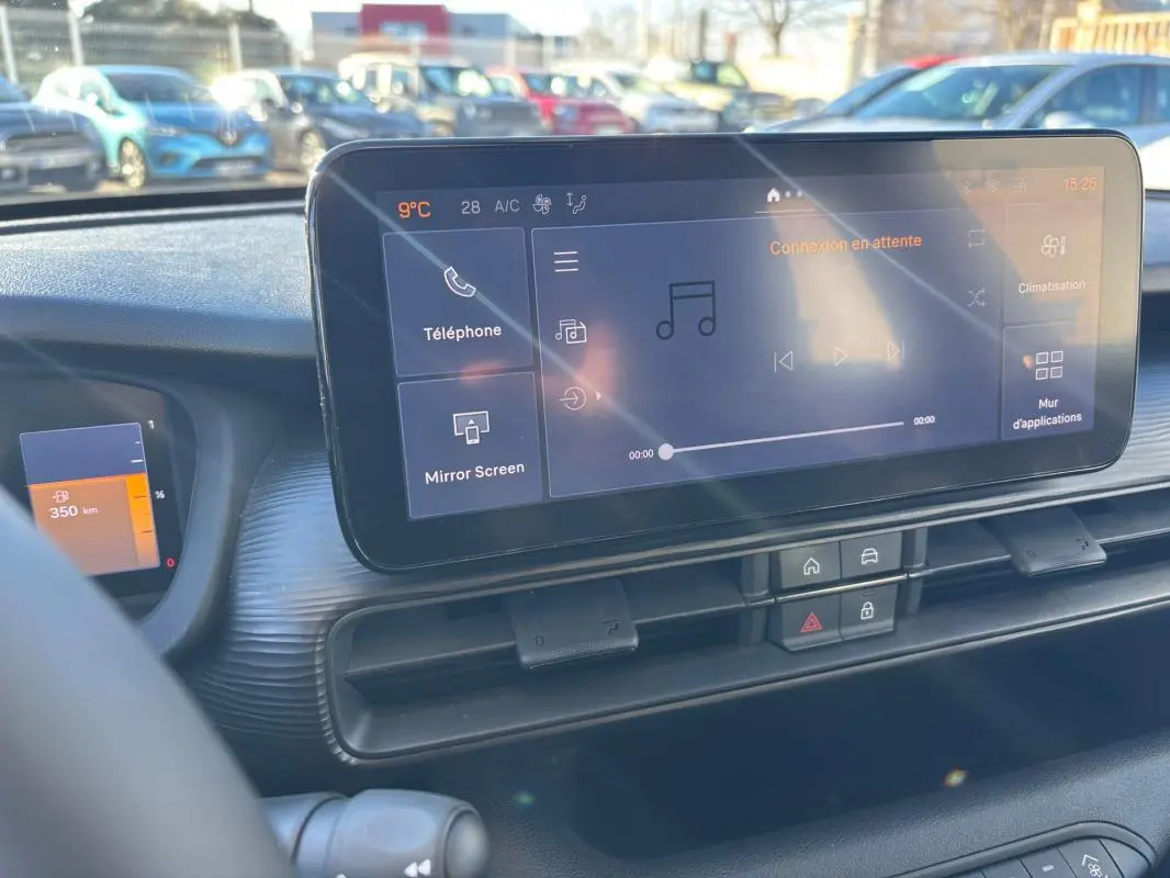 Vue intérieure du tableau de bord du Jeep Avenger 2024 noir, avec écran tactile central et commandes de climatisation.