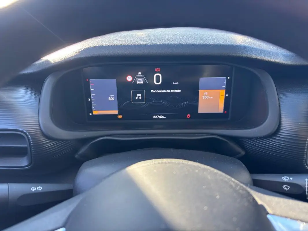 Vue rapprochée du tableau de bord numérique du Jeep Avenger noir 2024, affichant la vitesse et les alertes.