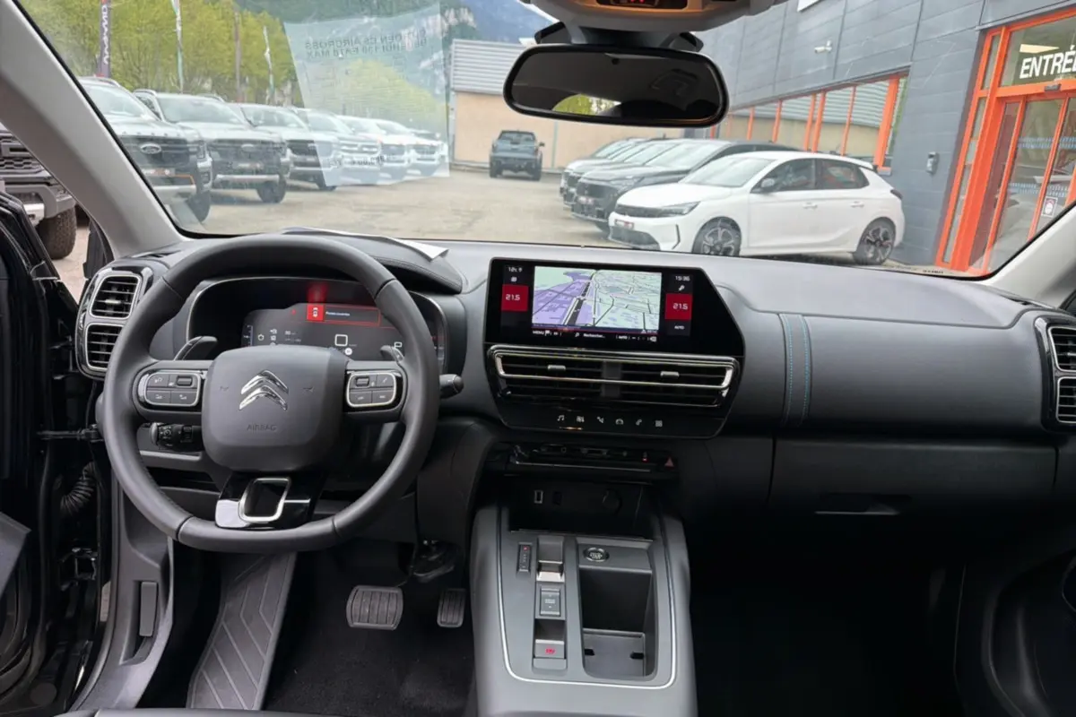 Vue intérieure frontale du tableau de bord et volant noir du Citroën C5 Aircross 2025 avec écran tactile et console centrale moderne.