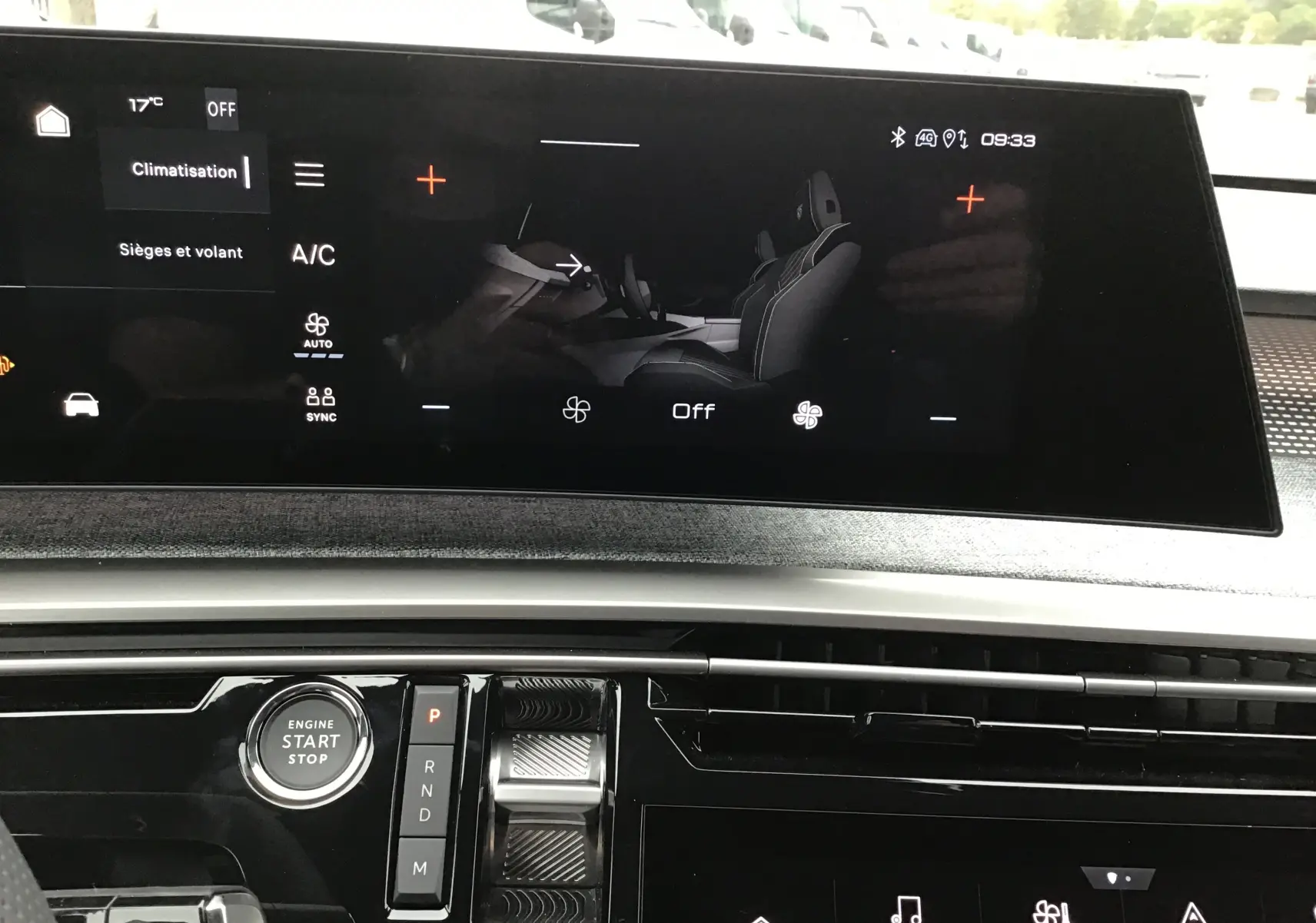 Vue intérieure du tableau de bord du Peugeot 3008 hybride 2026, écran tactile affichant la climatisation et commandes modernes.