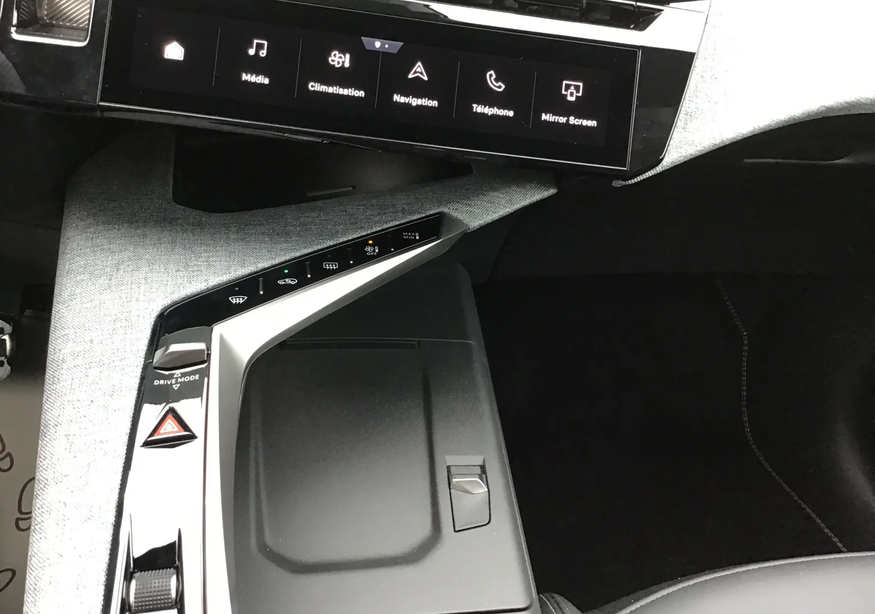Vue intérieure du Peugeot 3008 2026, console centrale avec finition tissu gris clair et écran tactile noir affichant les commandes multimédia.