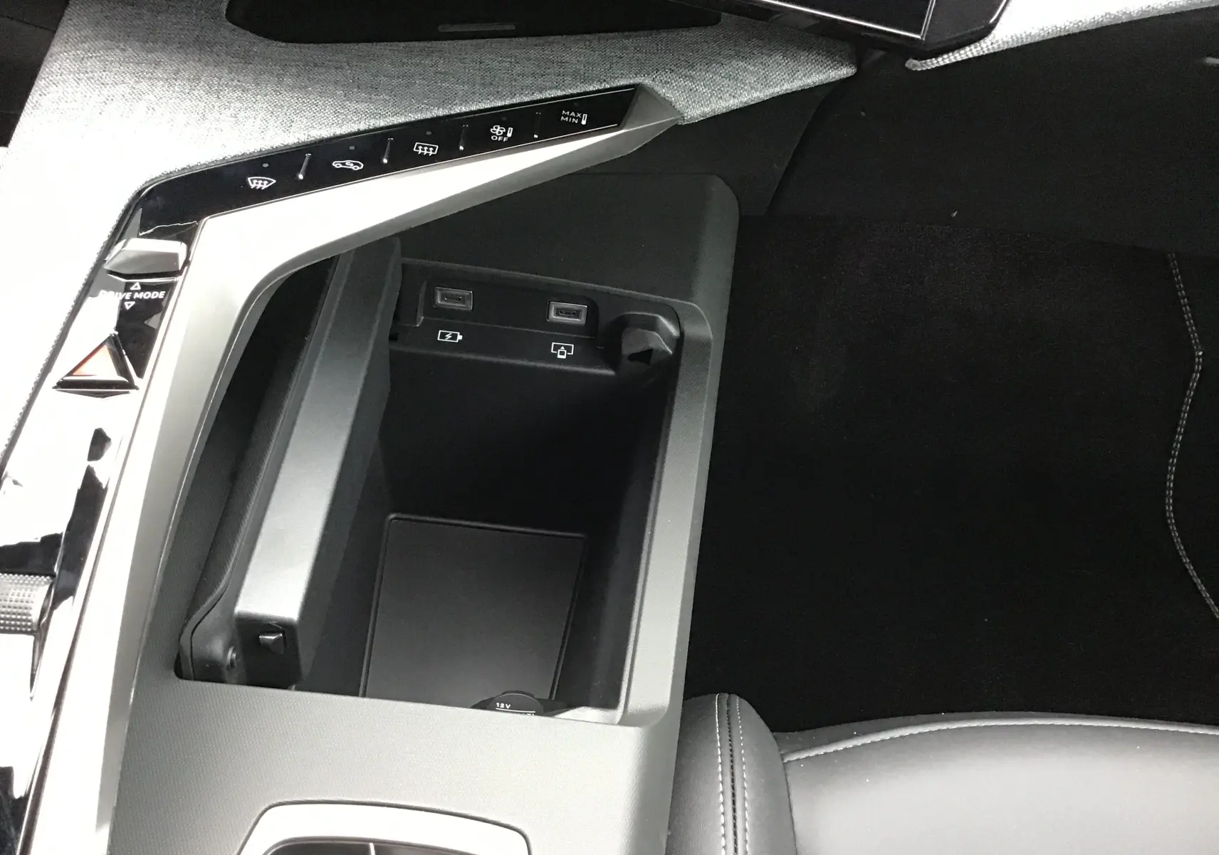 Gros plan intérieur sur la console centrale du Peugeot 3008 1.2 Hybrid 145, avec ports USB et commandes tactiles.