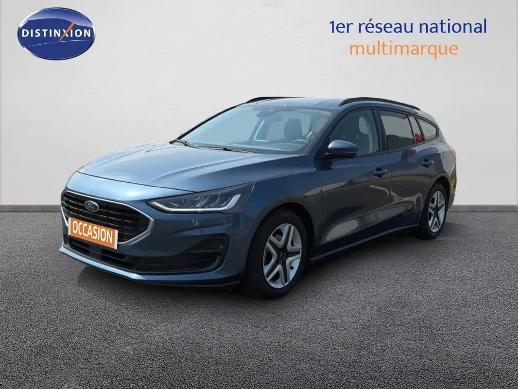 Ford Focus SW bleu foncé vue 3/4 avant droit avec barres de toit et jantes classiques 16 pouces.