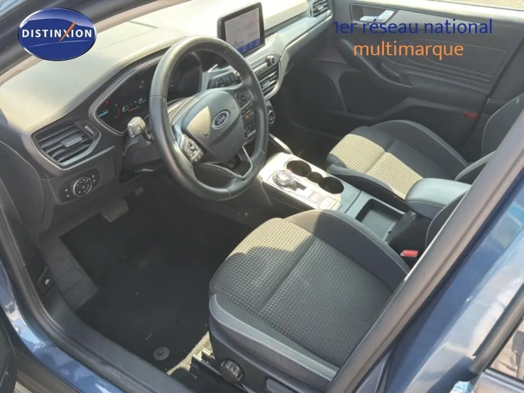 Vue intérieure côté conducteur de la Ford Focus SW 2022 bleu foncé, avec tableau de bord et console centrale moderne.