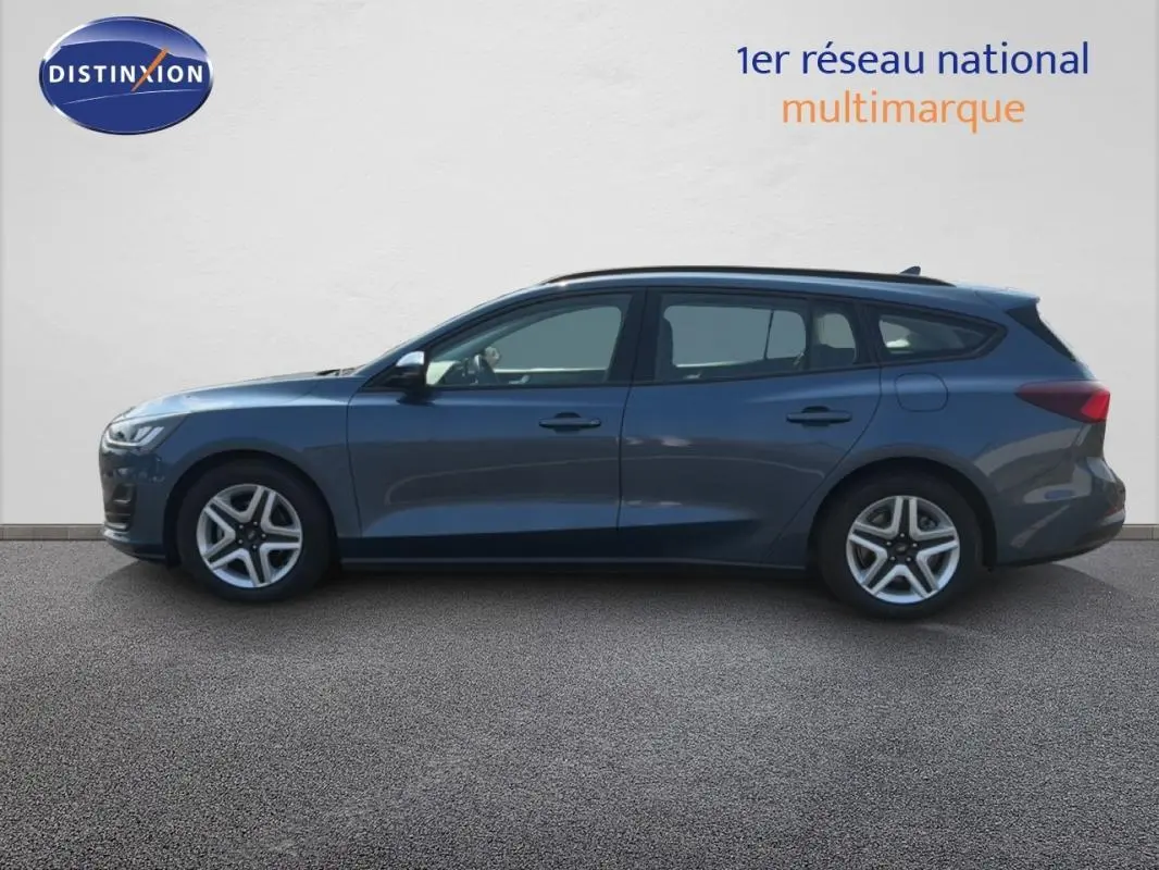 Vue de profil côté gauche d'une Ford Focus SW bleu foncé 2022 avec barres de toit et jantes 16 pouces classiques.