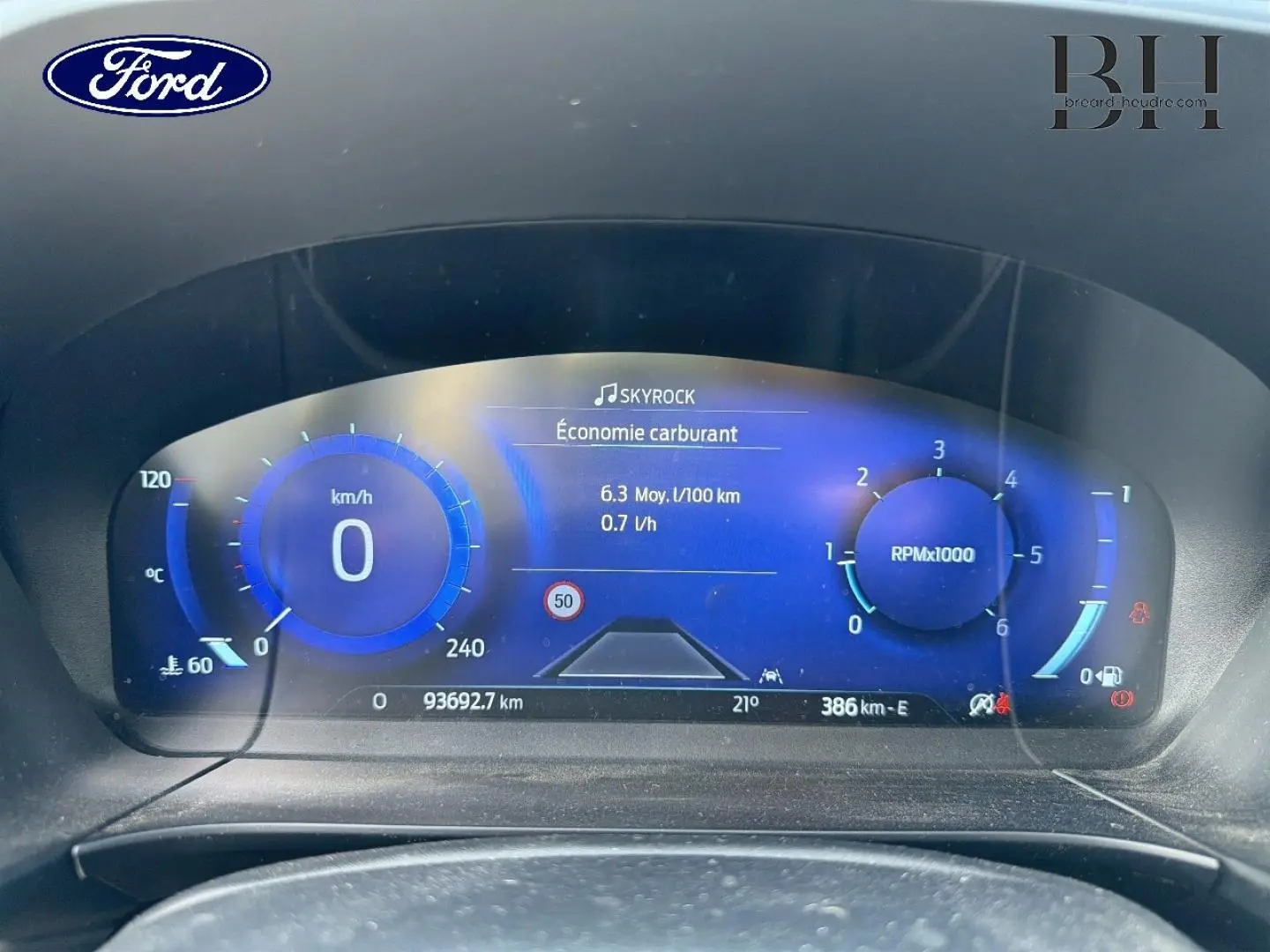 Tableau de bord numérique bleu du Ford Kuga 2020 affichant consommation, vitesse et compte-tours à 0 km/h.