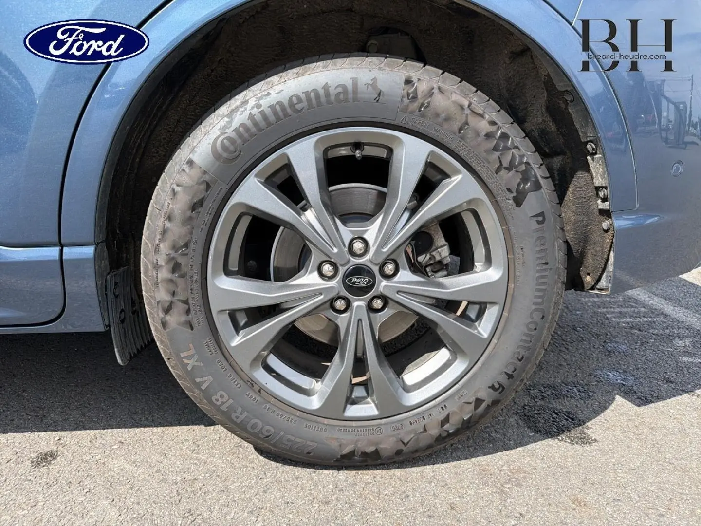 Gros plan sur la roue avant gauche du Ford Kuga bleu, jante alliage 18 pouces avec pneu Continental.