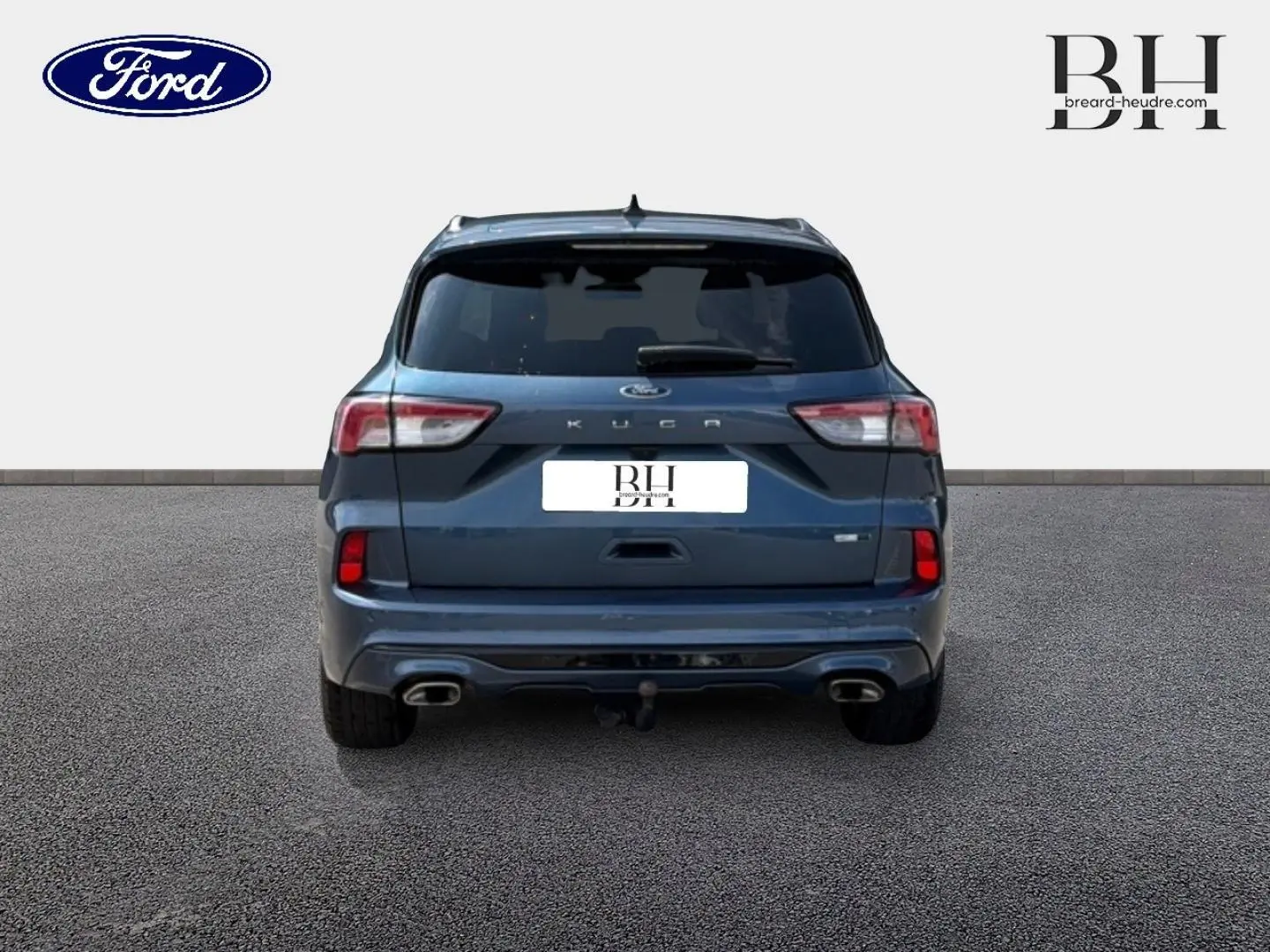 Vue arrière d'un Ford Kuga bleu Abysse 2020 avec double sortie d'échappement et vitres arrière surteintées.