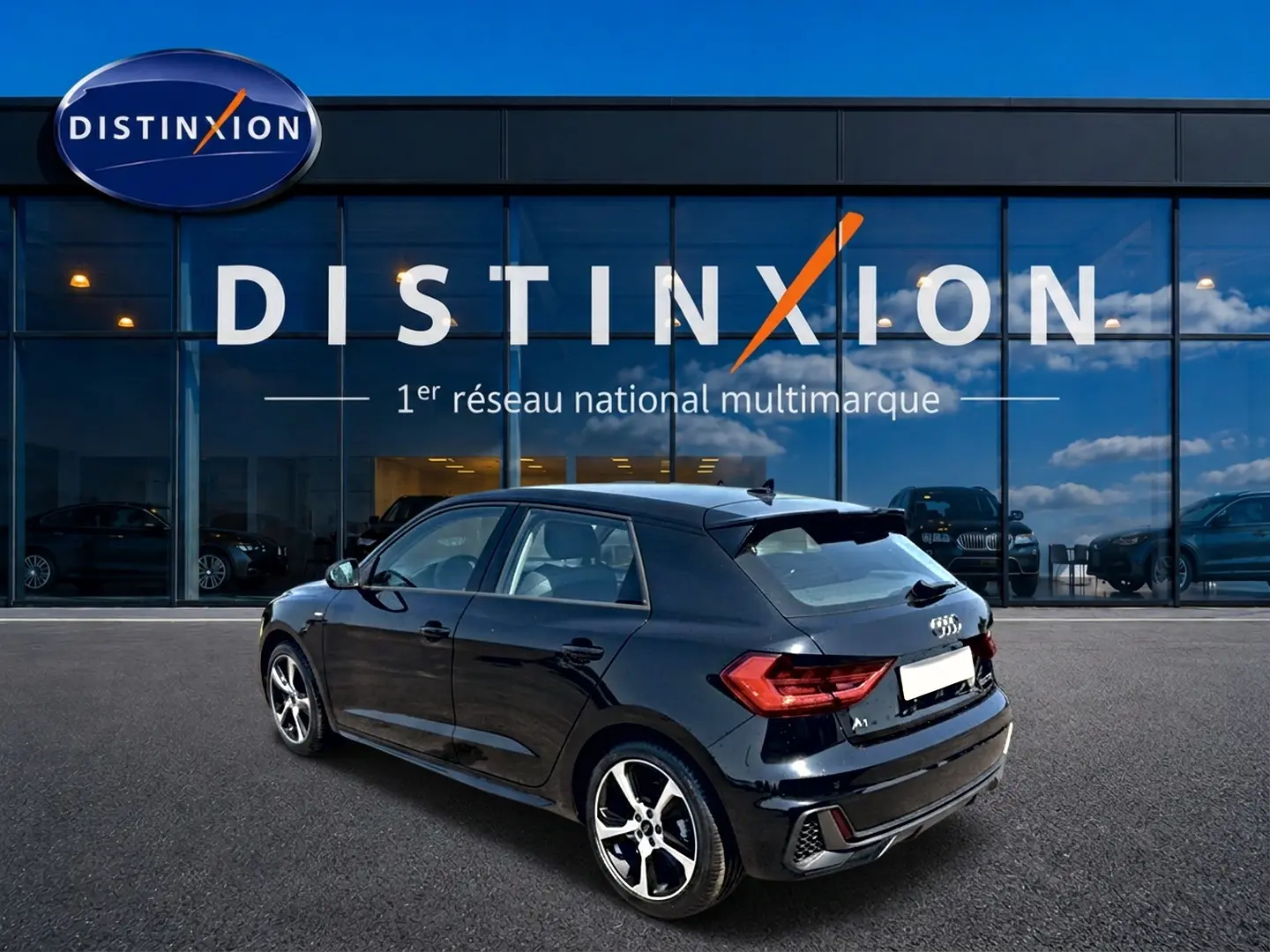 Audi A1 Sportback noir vue 3/4 arrière droit, avec jantes alliage et becquet arrière distinctif.