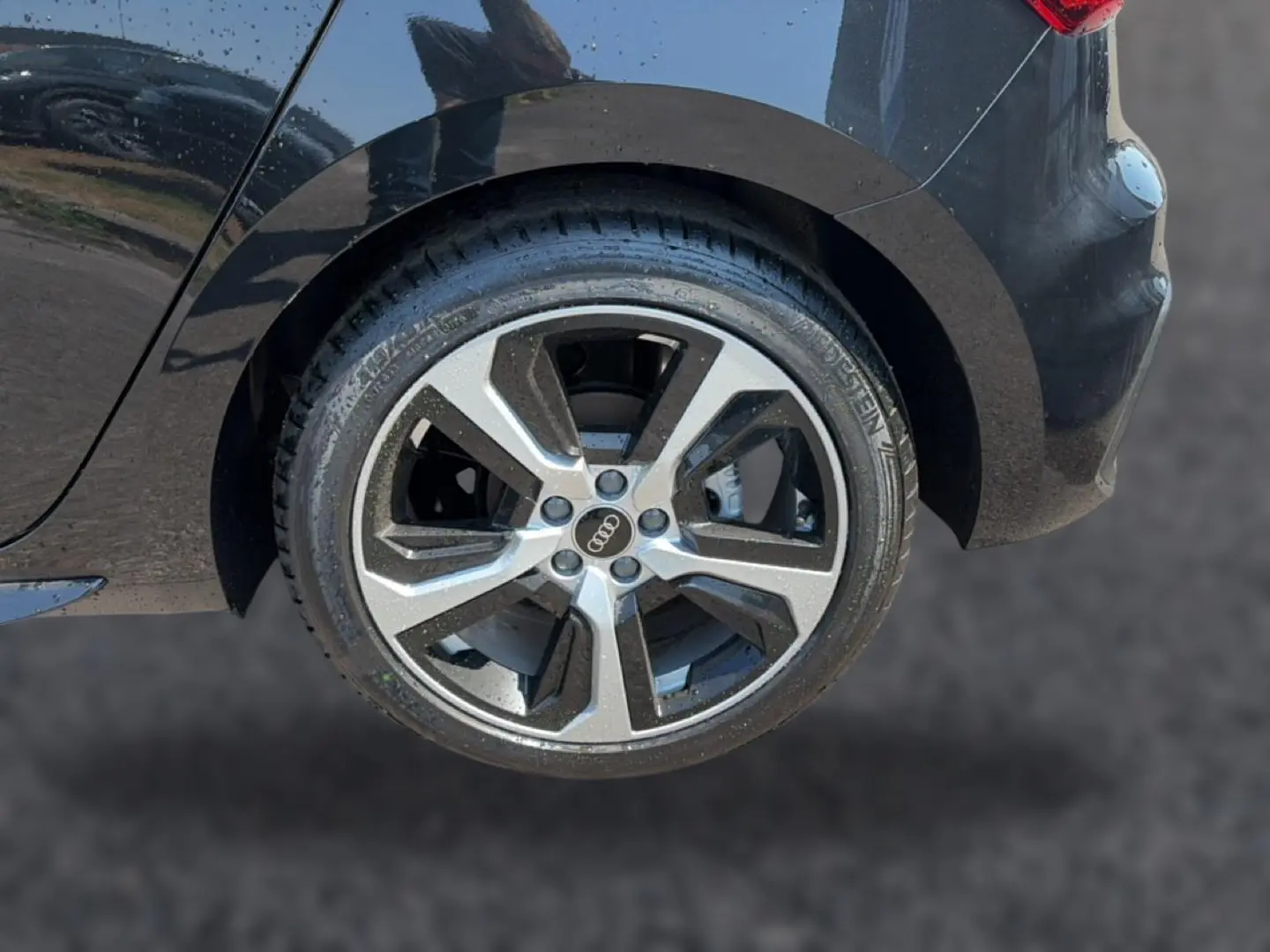 Gros plan sur la roue arrière droite noire d’une Audi A1 Sportback 30 TFSI S line avec jante alu bicolore.