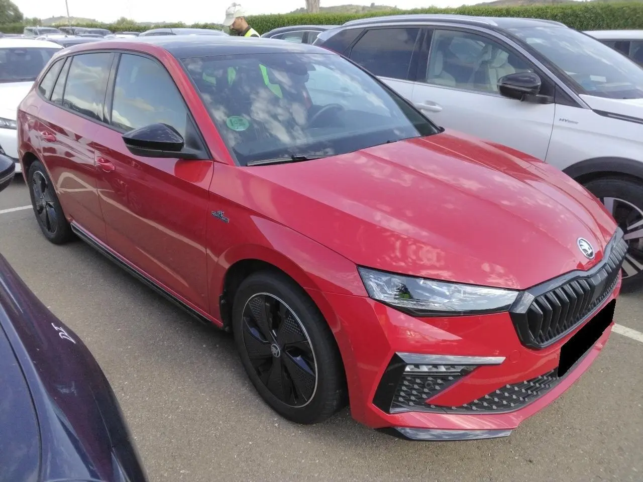 Vue 3/4 avant droite d'une Skoda Scala TSI 116 Monte-Carlo rouge Velvet avec jantes noires et toit panoramique.