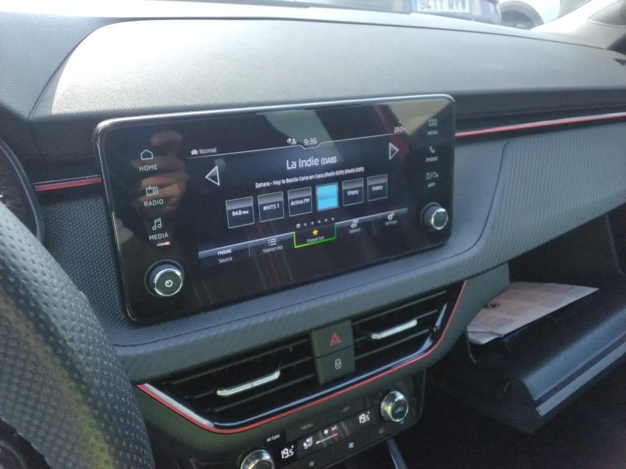 Vue rapprochée de la console centrale de la Skoda Scala Monte-Carlo 2025, avec écran tactile et inserts rouges décoratifs.