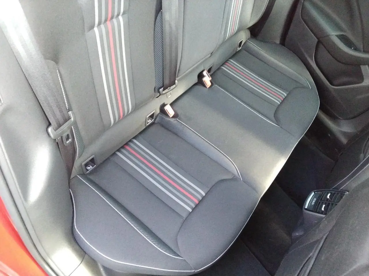 Vue intérieure de la banquette arrière noire avec bandes grises et rouges du Skoda Scala Monte-Carlo Rouge Velvet.