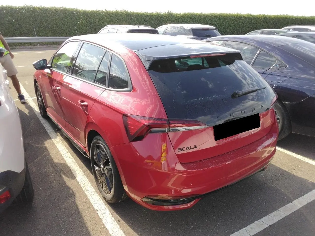 Vue 3/4 arrière droite d'une Skoda Scala TSI 116 DSG7 Monte-Carlo Rouge Velvet avec toit panoramique et hayon électrique.