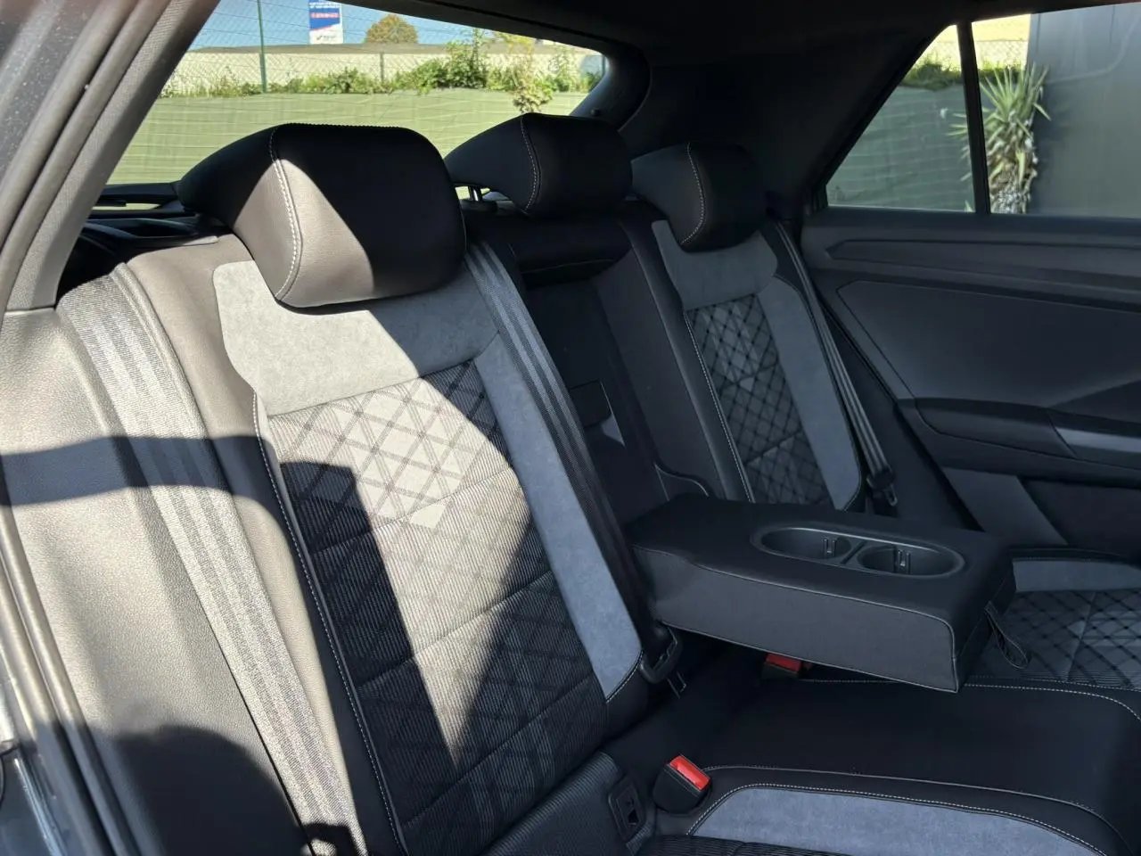 Vue intérieure côté droit des sièges arrière gris et noirs avec accoudoir central déployé du Volkswagen T-Roc 2025 R-Line