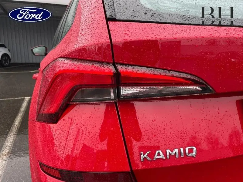 Gros plan sur le feu arrière gauche rouge métallisé du Skoda Kamiq 2022 avec logo KAMIQ visible sous la pluie.