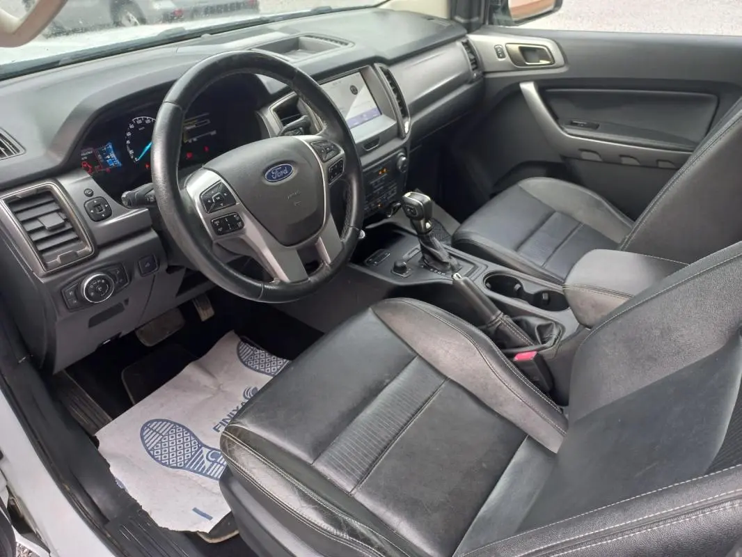 Vue intérieure côté conducteur du Ford Ranger 2022, montrant le volant, tableau de bord et sièges en cuir noir.