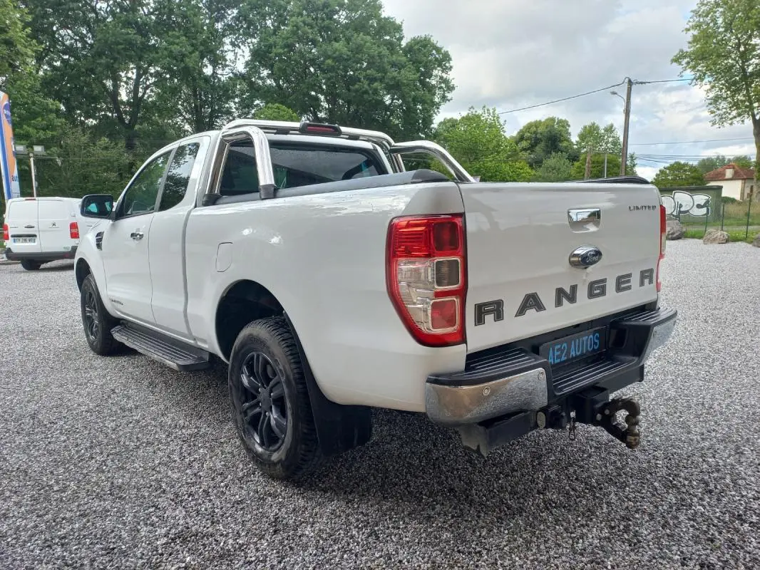 Ford Ranger Super Cabine Limited blanc vu en 3/4 arrière droit, avec barres de protection chromées et roues noires.