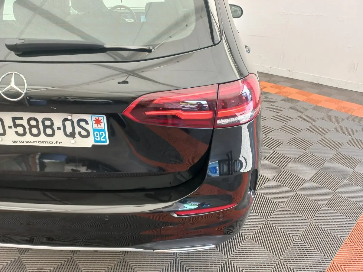 Vue arrière droite d'une Mercedes Classe A Berline A 200 AMG Line noire avec feux LED et plaque d'immatriculation française.