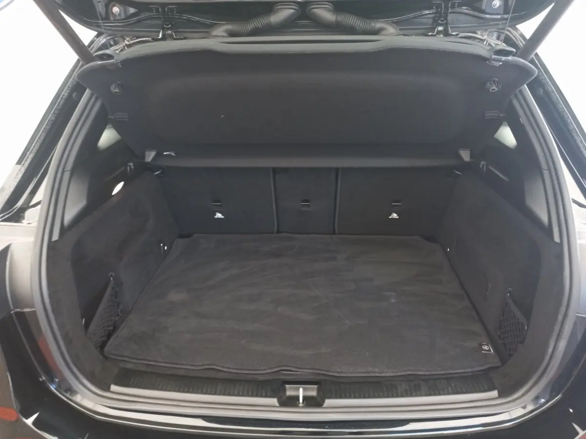 Coffre ouvert noir de la Mercedes Classe A Berline A 200 AMG Line, vue de l’arrière montrant l’espace de chargement.