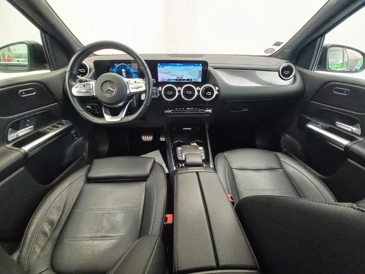 Vue intérieure avant de la Mercedes Classe A A 200 AMG Line 2021, avec sièges cuir noirs et tableau de bord numérique.
