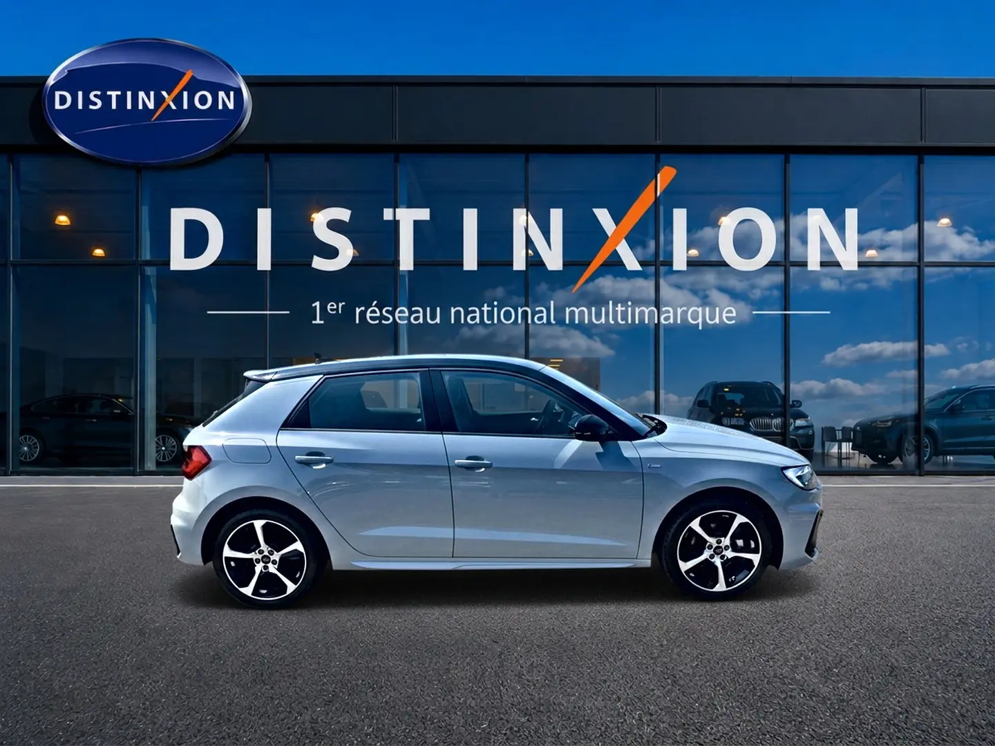Audi A1 Sportback gris arrow vue de profil côté gauche devant une vitrine avec logo Distinxion.