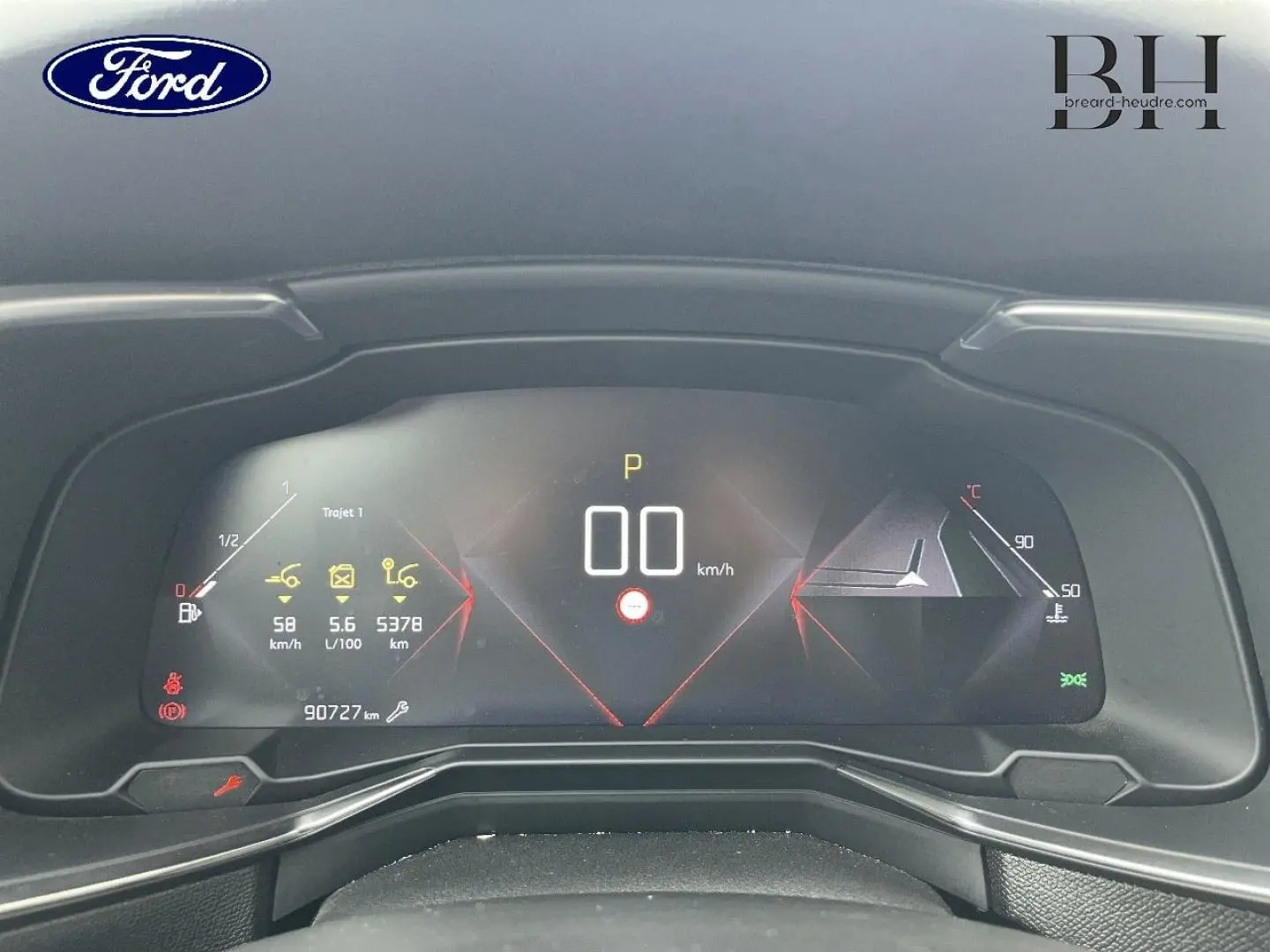 Tableau de bord numérique d'un DS7 Crossback rouge, affichant la vitesse à 0 km/h et diverses informations de conduite.