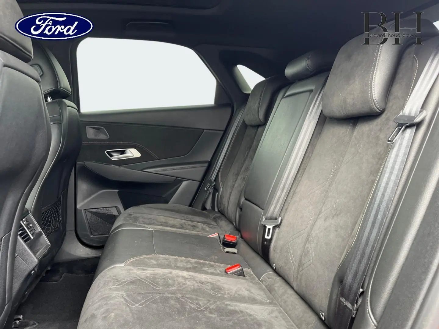 Vue intérieure côté droit sur la banquette arrière en cuir noir du DS7 Crossback Rouge Absolu avec ceintures et appuie-têtes.