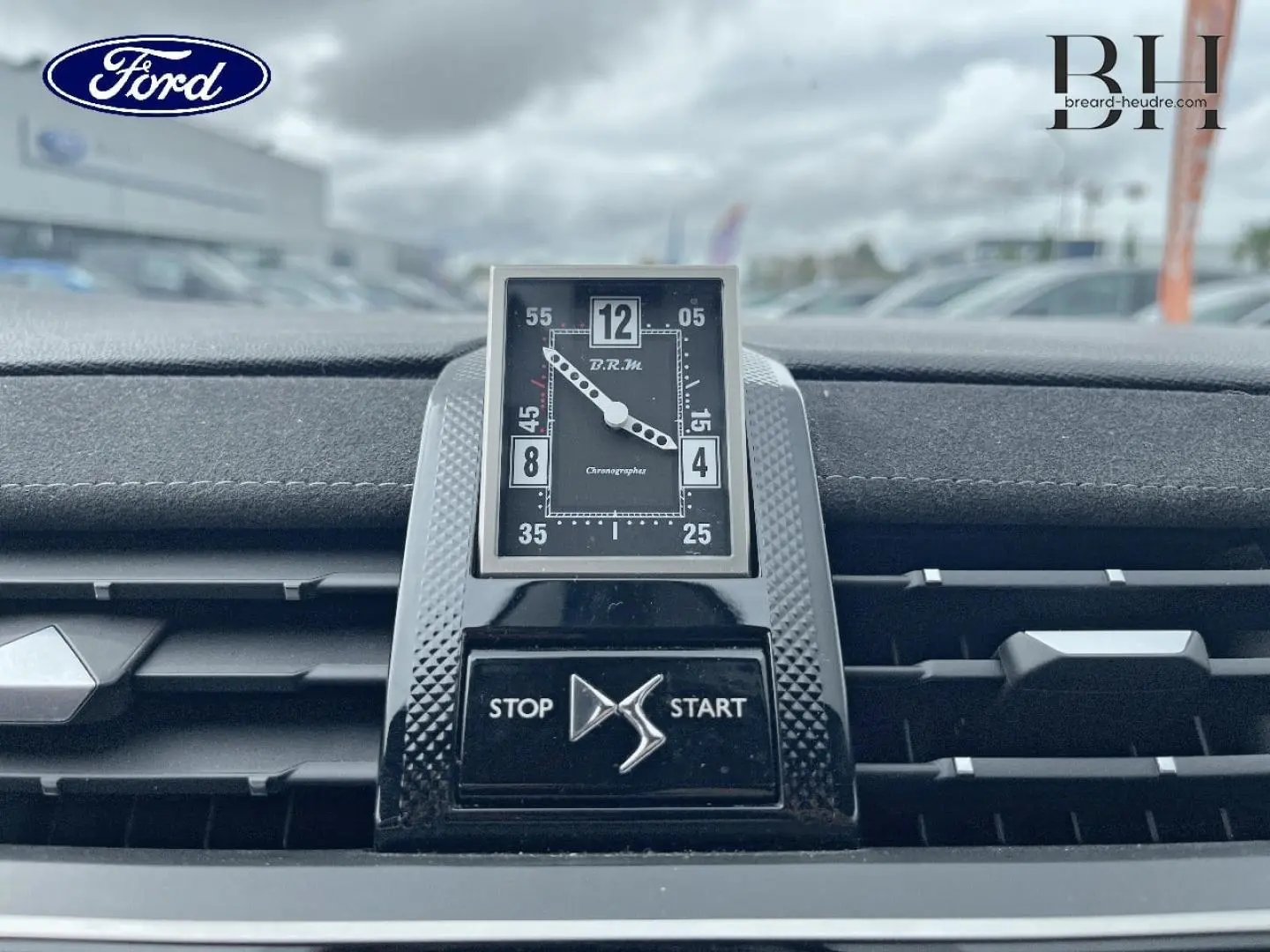 Gros plan sur l'horloge B.R.M R180 et la commande Stop/Start au centre du tableau de bord du DS7 Crossback rouge.