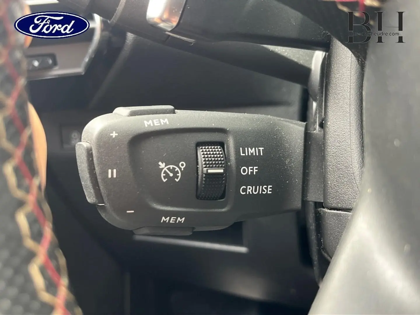 Gros plan sur la commande de régulateur de vitesse d'une DS7 Crossback rouge, avec molette et inscriptions LIMIT OFF CRUISE.