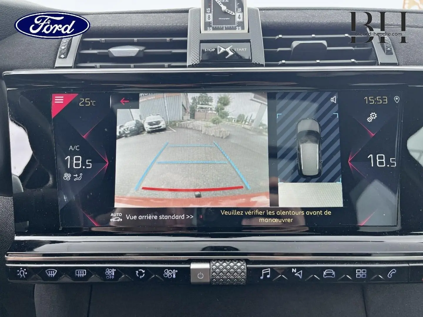 Écran tactile intérieur du DS7 Crossback rouge montrant la caméra de recul et l'affichage de la climatisation.