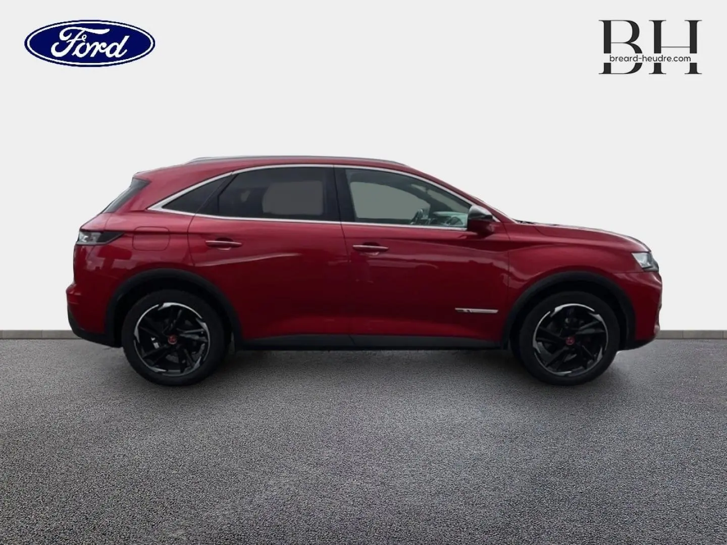 Vue de profil côté gauche du DS7 Crossback rouge Absolu avec jantes noires et toit ouvrant panoramique visible.