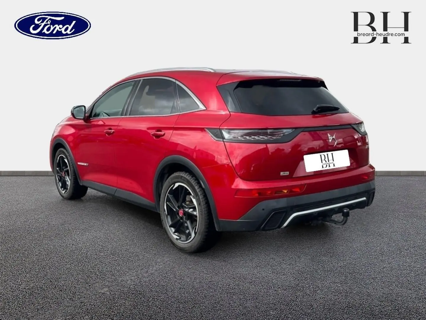Vue 3/4 arrière droite du SUV DS7 Crossback rouge Absolu avec toit ouvrant panoramique et jantes noires.