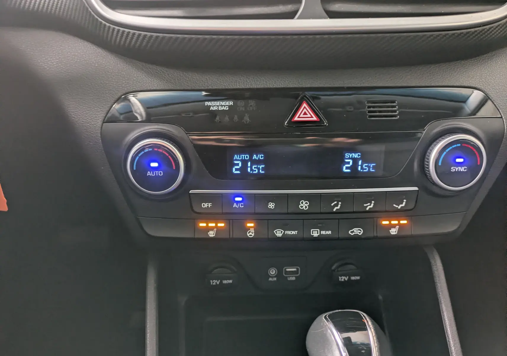 Vue rapprochée de la console centrale noire du Hyundai Tucson 2020, affichant la climatisation automatique et les commandes chauffantes.