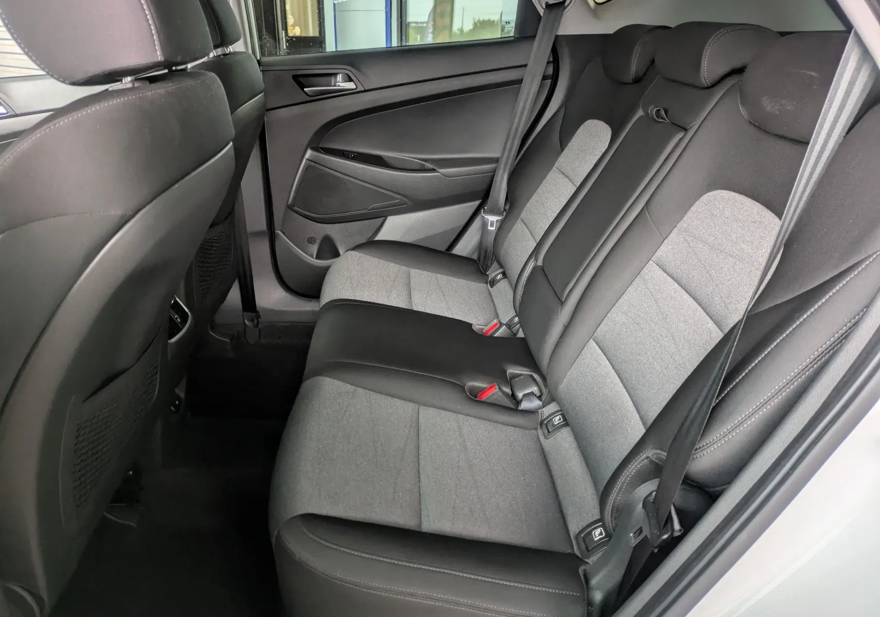 Vue intérieure côté droit des sièges arrière bicolores gris et noir du Hyundai Tucson blanc de 2020.