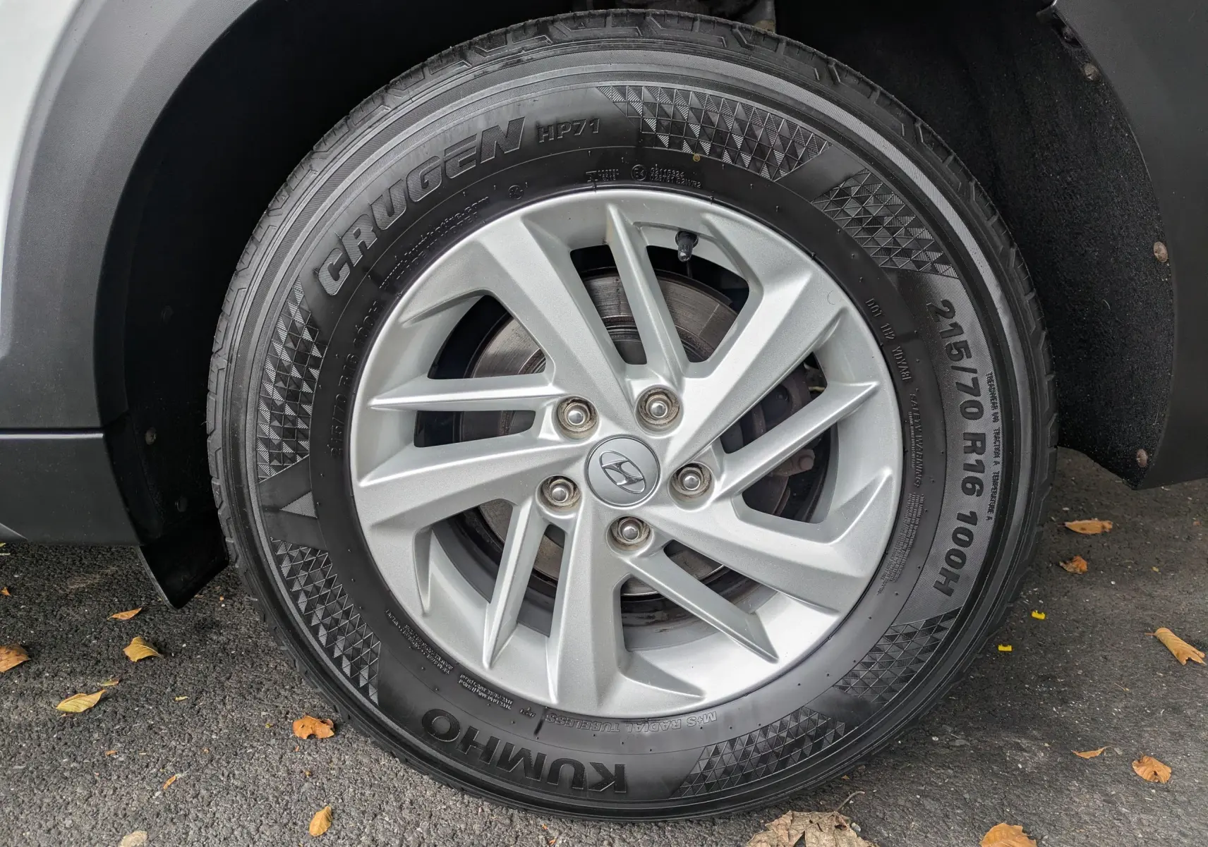 Gros plan sur la roue avant gauche du Hyundai Tucson blanc, mettant en valeur la jante argentée et le pneu Kumho.