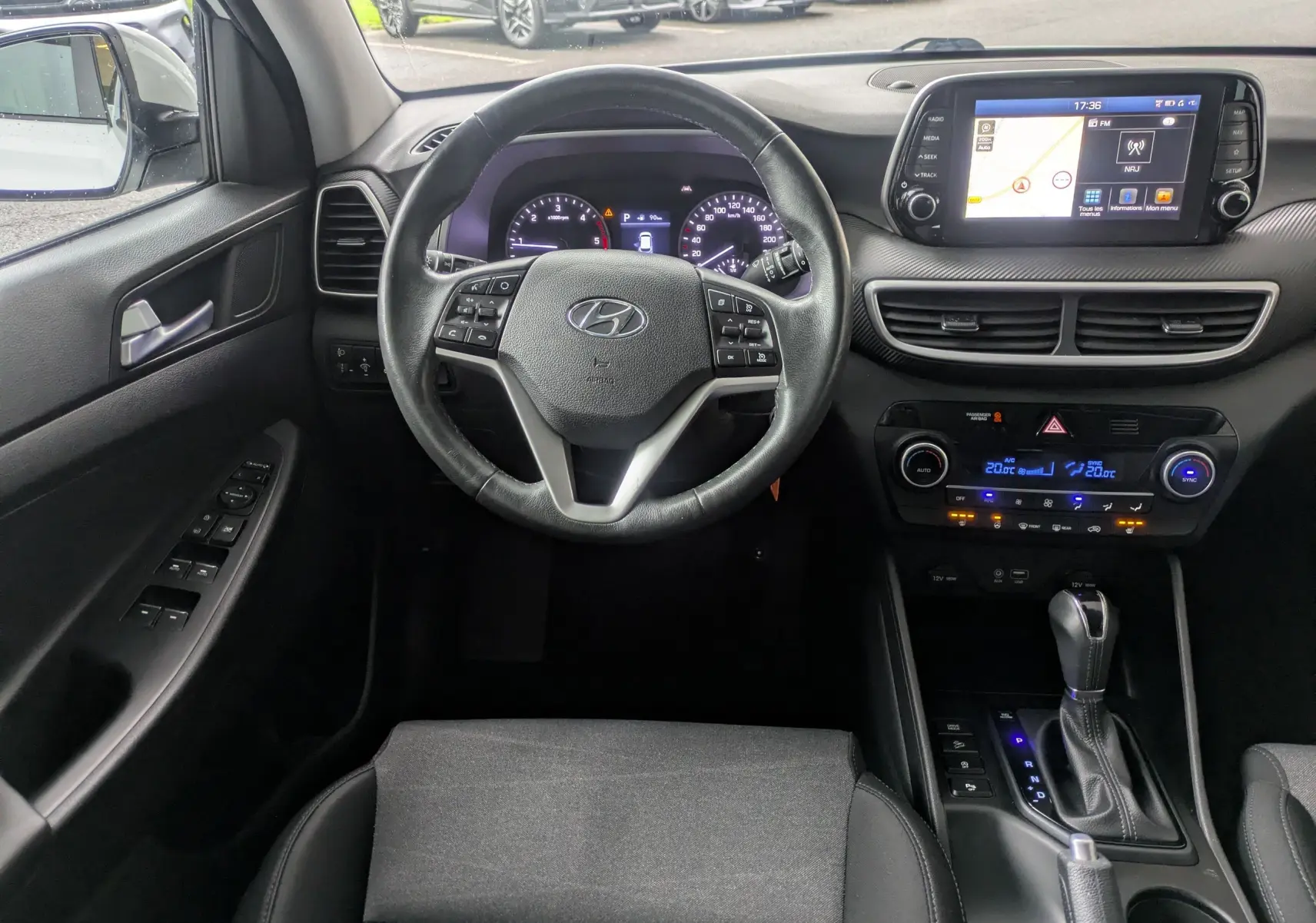Vue intérieure centrée sur le volant et le tableau de bord du Hyundai Tucson 2020, avec écran tactile et commandes au volant.