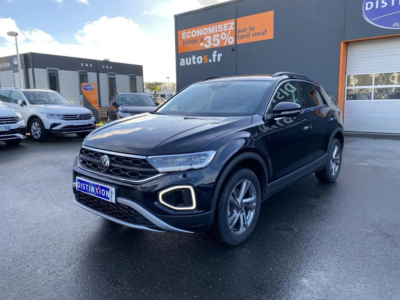 Volkswagen T-Roc noir nacré 2025 en 3/4 avant droit, avec feux LED et jantes alliage visibles sur parking.