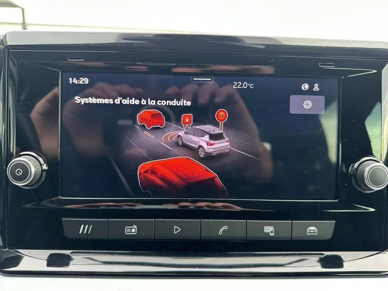 Écran central du SEAT Arona 2025 montrant les systèmes d'aide à la conduite avec interface graphique en couleurs.