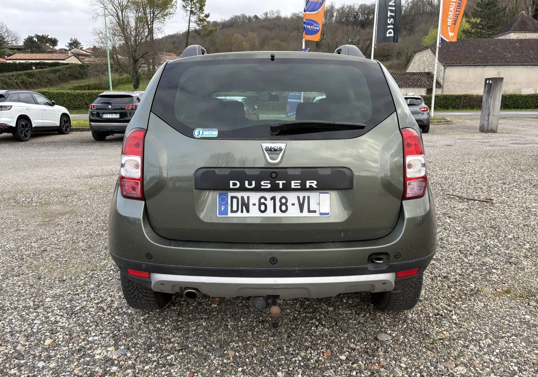 Vue arrière d'un Dacia Duster 1.5 DCI 110 vert foncé de 2014 avec attelage et plaque d'immatriculation française.