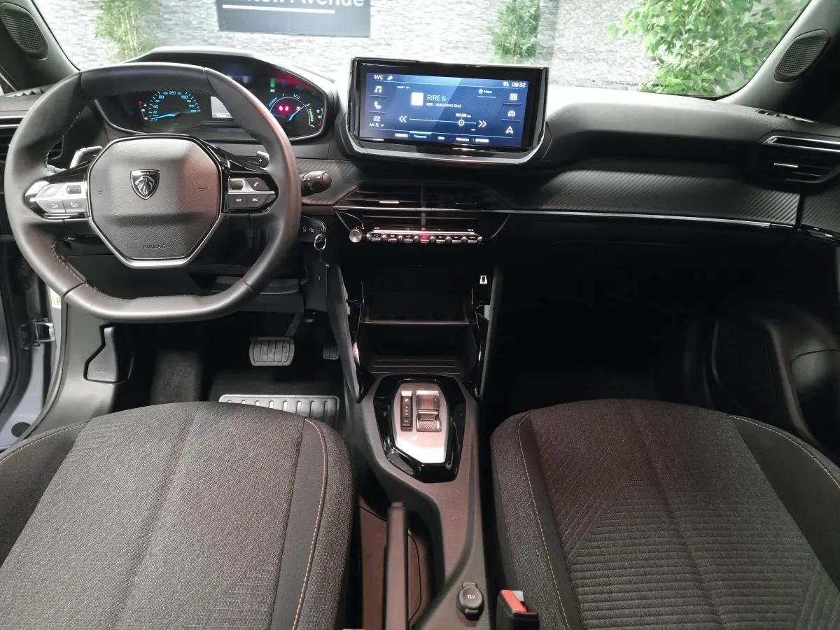 Intérieur Peugeot 2008 2025 vu de face, tableau de bord noir avec écran tactile 10 pouces et volant compact cuir.