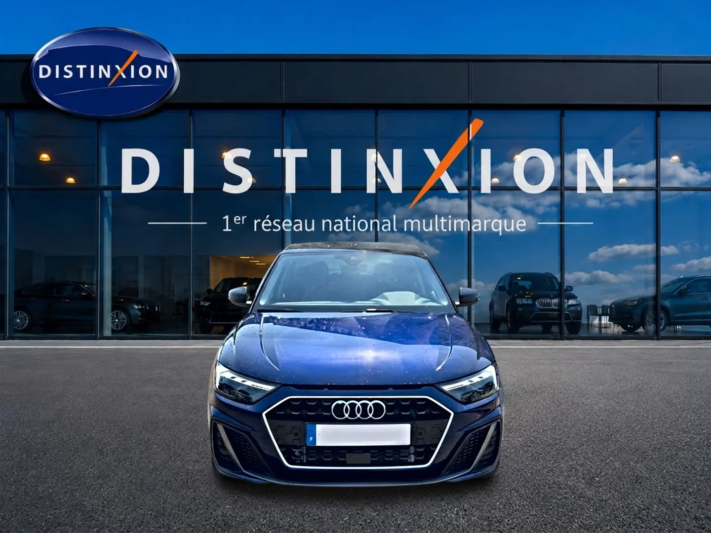 Audi A1 Sportback 30 TFSI 116 S line bleu foncé vue de face devant une vitrine Distinxion.