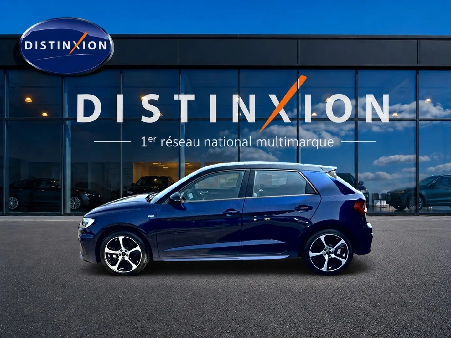 Audi A1 Sportback bleu foncé vue de profil côté gauche devant une vitrine avec logo Distinxion.